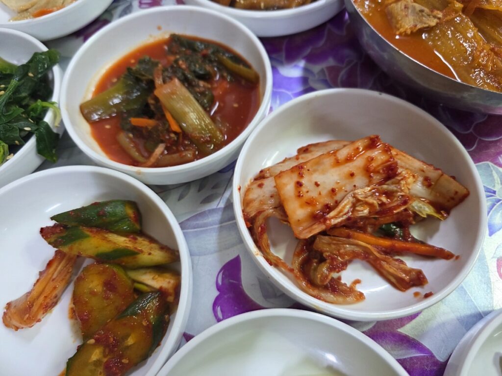 8 Vegan Banchan Secrets for a Stress-Free Korean Food Trip showing various assorted plant-based sides