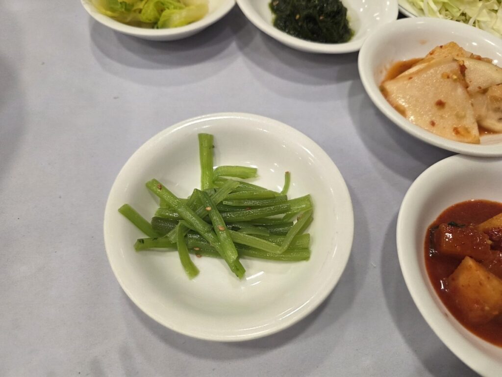 8 Vegan Banchan Secrets for a Stress-Free Korean Food Trip showing braised eggplant with sesame seeds