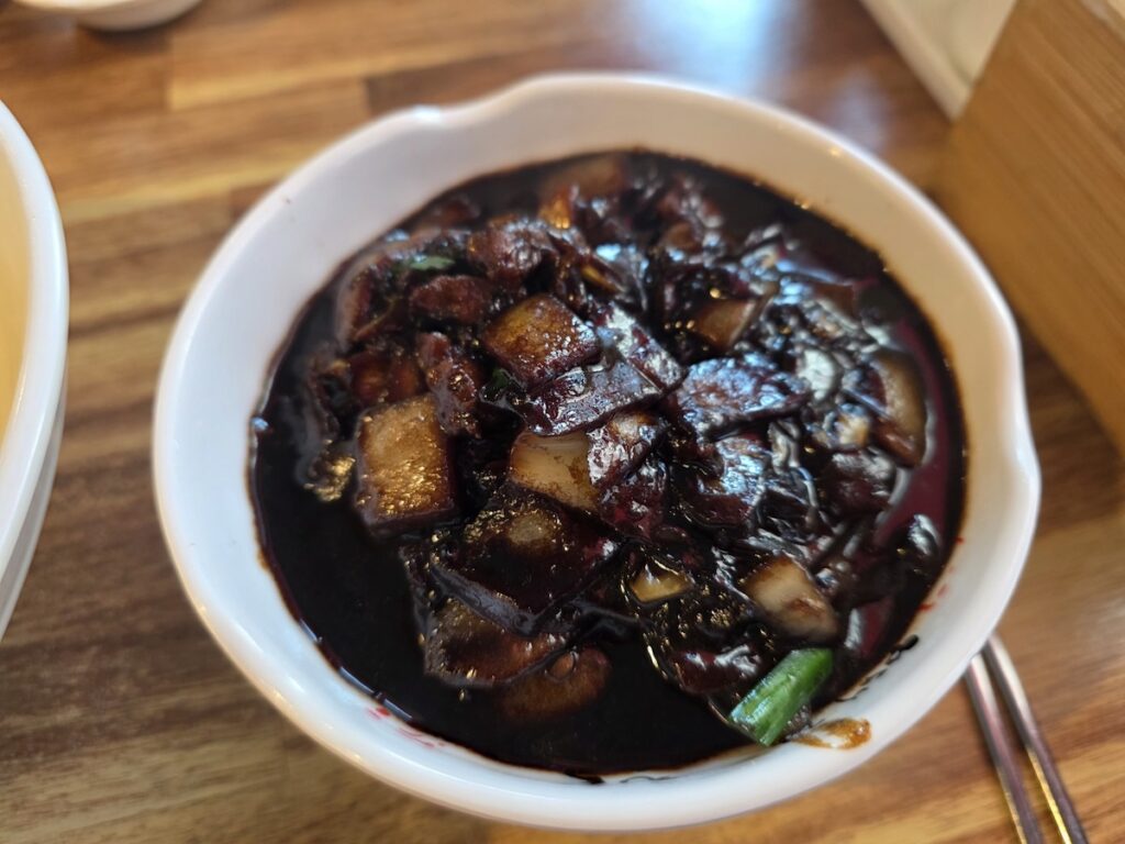A rich, obsidian-colored Ganjajang sauce with stir-fried onions and pork for Korean black bean noodles.