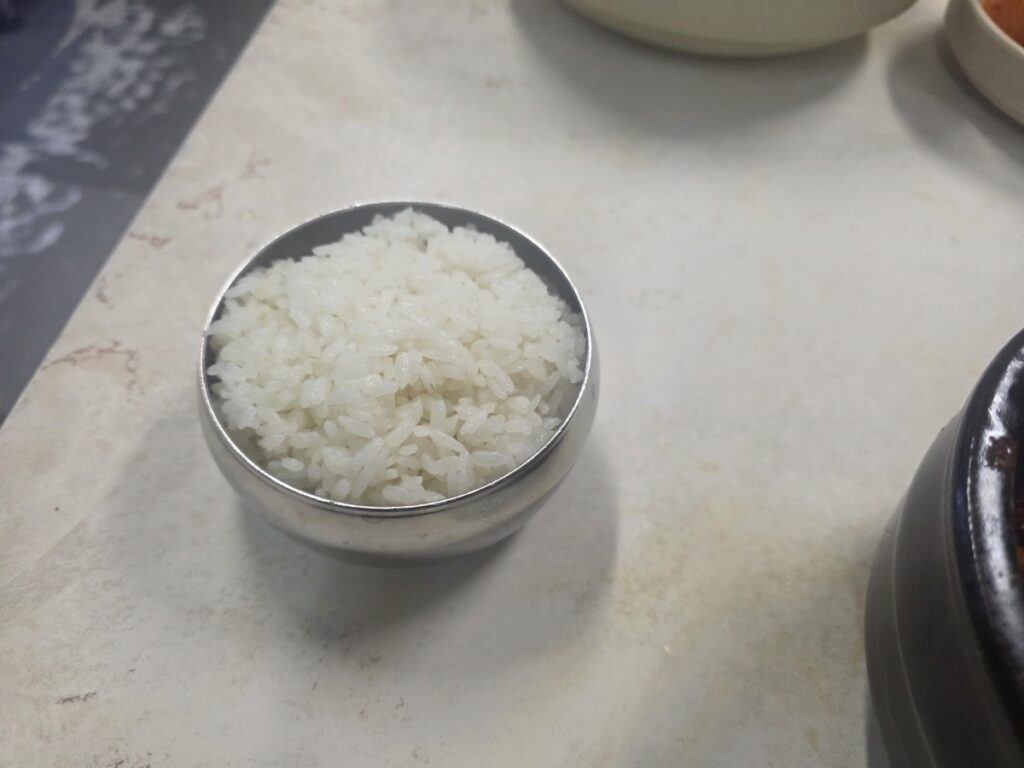 A fresh bowl of steamed white rice ready to be mixed into the spicy broth of the Dangerous Midnight Food in Korea.