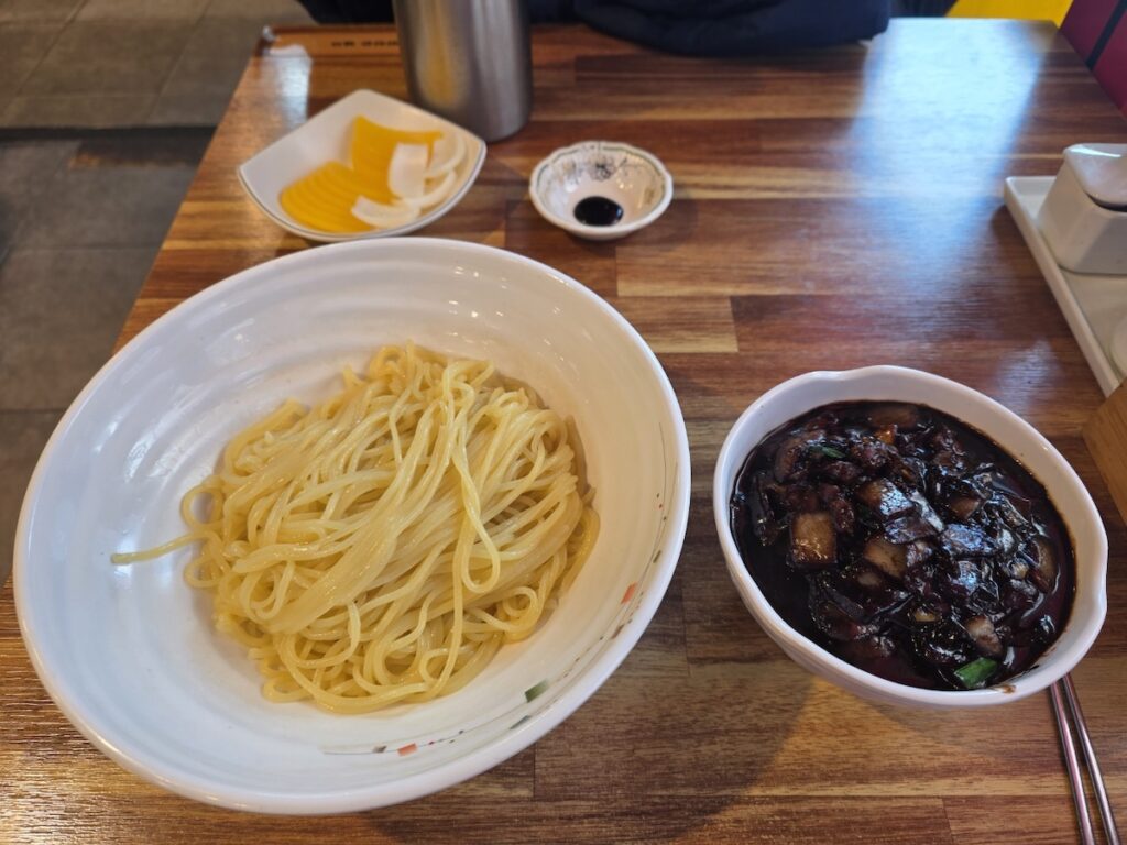 The traditional serving of Ganjajang where the savory sauce and Korean black bean noodles are served in separate bowls.