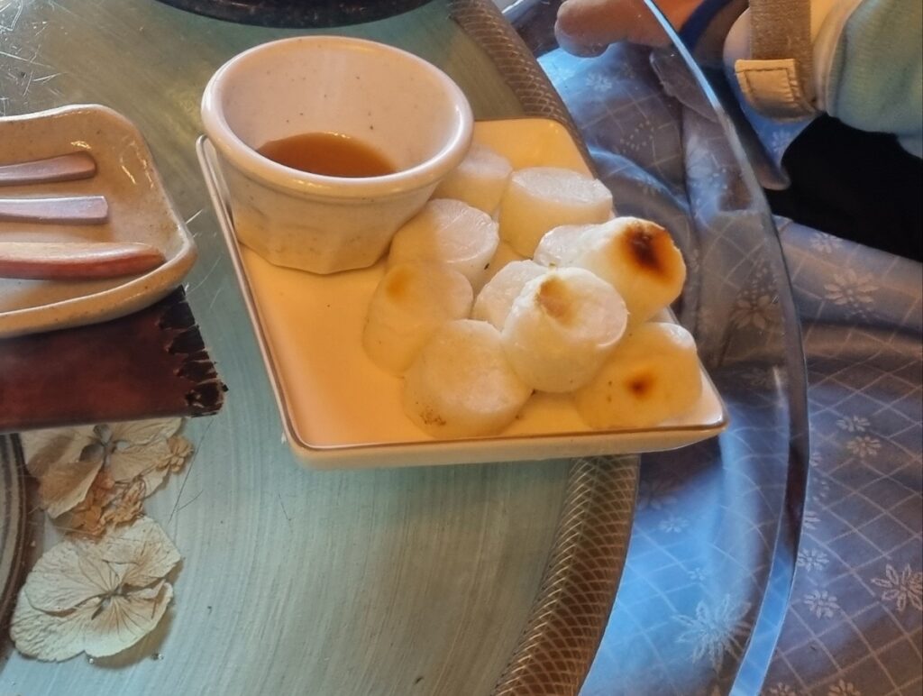 Cinematic close-up of grilled Korean rice cake Tteok served with sweet syrup, a traditional success ritual.