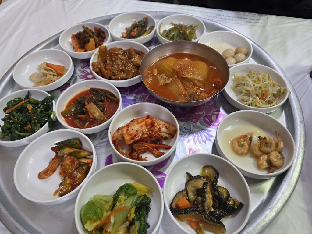 A lavish spread of 15 authentic Korean banchan side dishes on a traditional silver tray in Jeollanam-do province
