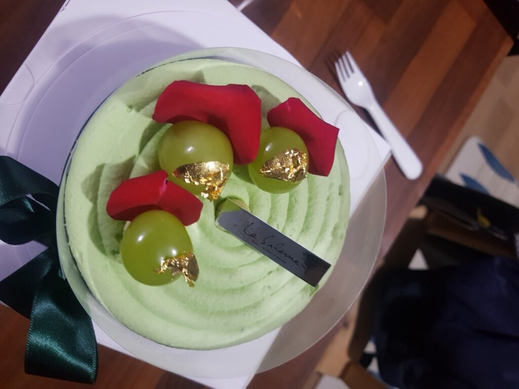 A premium Shine Muscat cake with gold leaf, representing the high-end luxury cake culture in Korea.