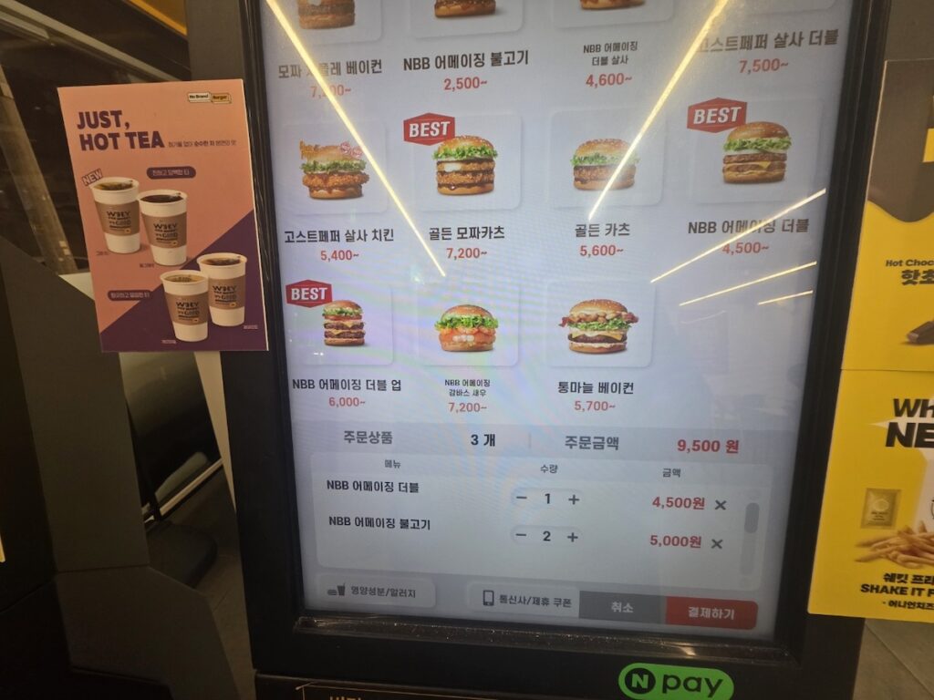 The menu selection screen on an NBB kiosk, displaying various burgers like NBB Amazing and Bulgogi Burger with their respective prices in KRW.
