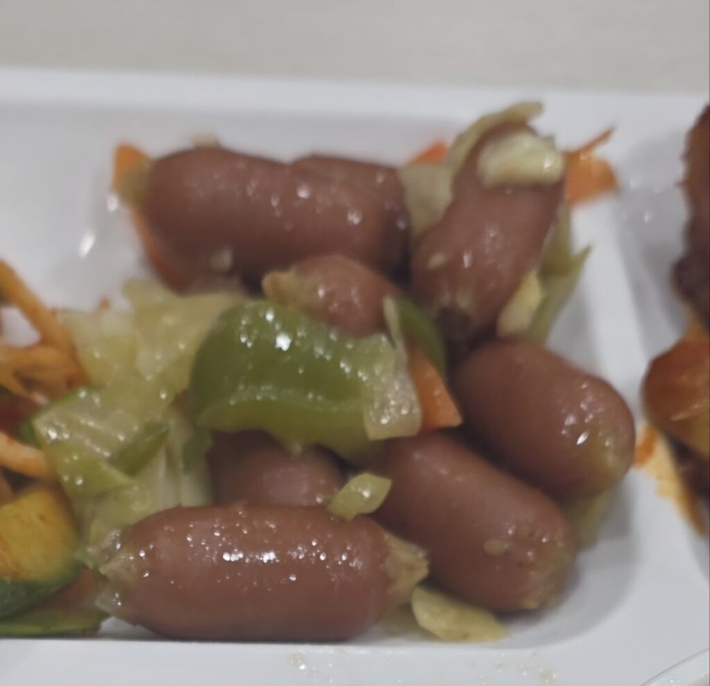 A close-up of pan-fried Vienna sausages, showcasing the high-meat content of the best Korean sausage brands for office lunch rituals like Nonghyup Moguchon and CJ CheilJedang.