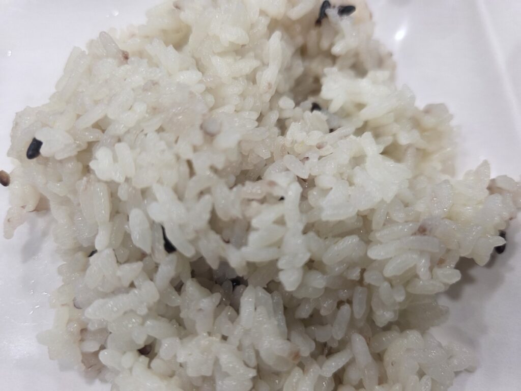 A neat portion of cooked white rice mixed with visible barley grains (Mugi-bap) on a white plate. This fibrous, complex carbohydrate is a key component of a balanced Korean meal plan, helping to prevent the blood sugar spikes that derail most weight loss diet attempts.