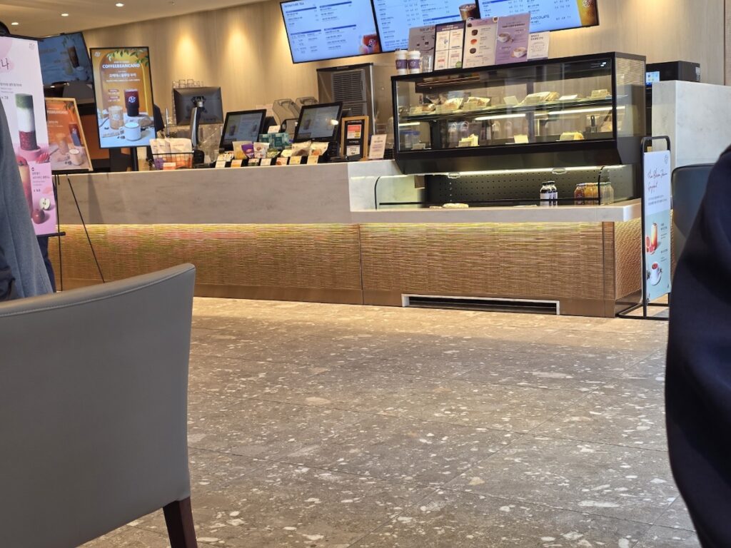 The clean and sophisticated interior of a Coffee Bean Korea store in 2026, showing the service counter and display.