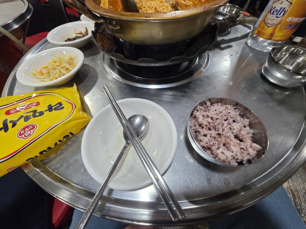 The essential triple side dish set of the **Gangnam Lunch Ritual** featuring mung bean sprouts, fish cakes, and perilla leaves for $6.00.