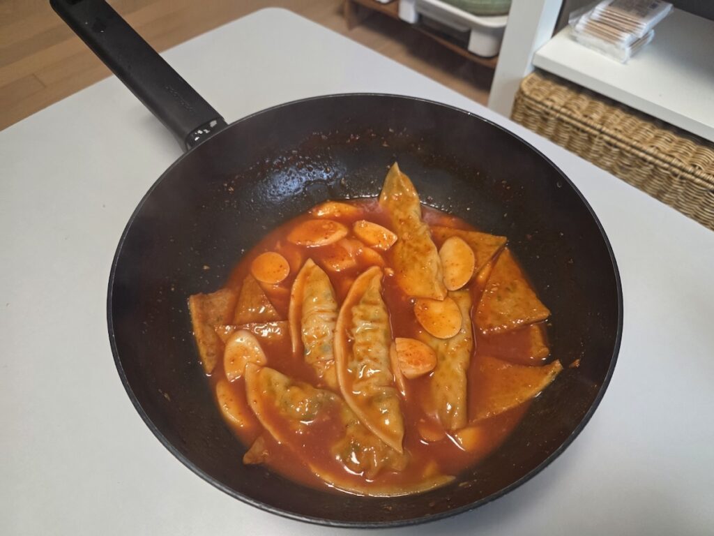 A close-up shot of the spicy sauce and chewy texture of rice cakes in the Homemade Tteokbokki Ritual 2026.