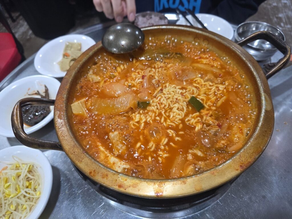 A steaming pot of traditional Kimchi-jjigae representing the initial stage of the **Ramyeon Sari Ritual** before adding noodles.
