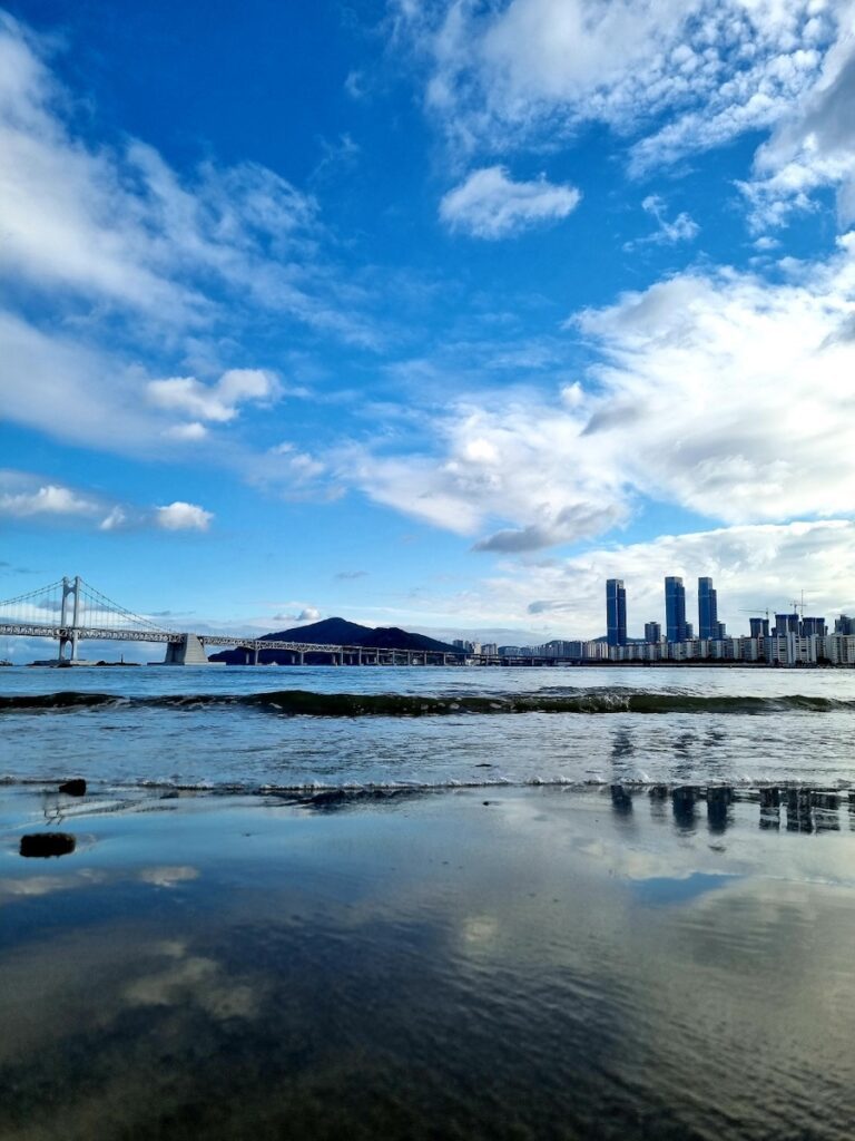 A cinematic view of the Gwangalli Bridge and the blue ocean in Busan, representing the coastal soul of the Korea Travel 2026 journey.