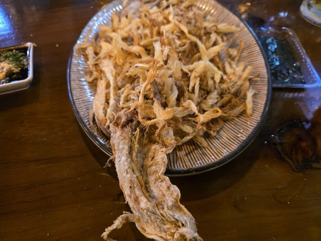 A full platter of crispy Meoktae (dried pollack), a staple appetizer in **Korean 2-cha Culture 2026**.