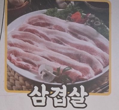 A close-up of fresh, thick-cut pork belly on the menu for the **Korean BBQ Pork Cuts Guide 2026**.