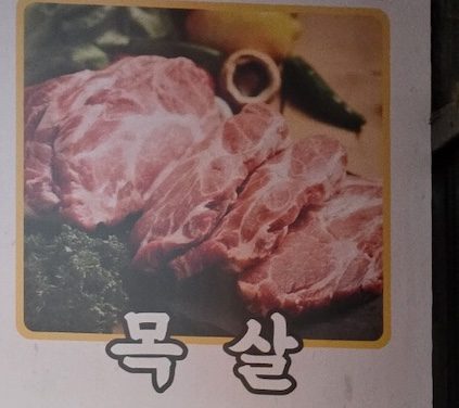 A visual of marbled pork shoulder steak on the menu for the **Korean BBQ Pork Cuts Guide 2026**.
