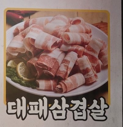 A display of thinly sliced, curled pork belly on the menu for the **Korean BBQ Pork Cuts Guide 2026**.
