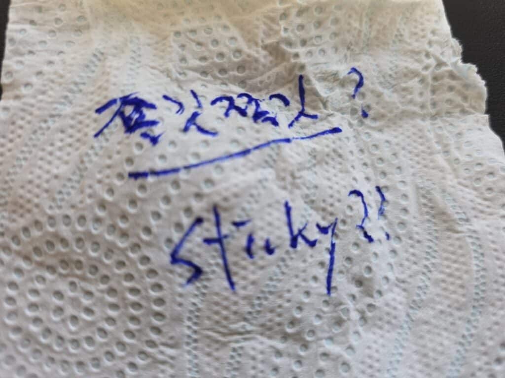 A handwritten note on a tissue asking 'Sticky? 끈적끈적?' as part of the Korean Food Texture Science 2026 exploration.