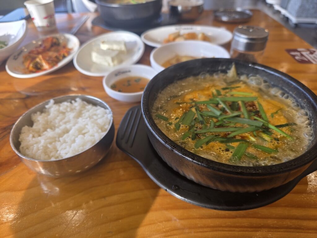 A close-up view of a restaurant fish tank filled with live, squirming mudfish (loach), the primary ingredient for Korean Energy Soup. This image captures the raw, powerful source of Stamina Food in Seoul.
