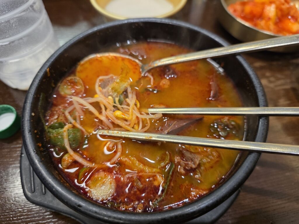 A steaming stone bowl of Haejangguk with bean sprouts and rich broth, the centerpiece of our Authentic Korean Hangover Soup Guide.