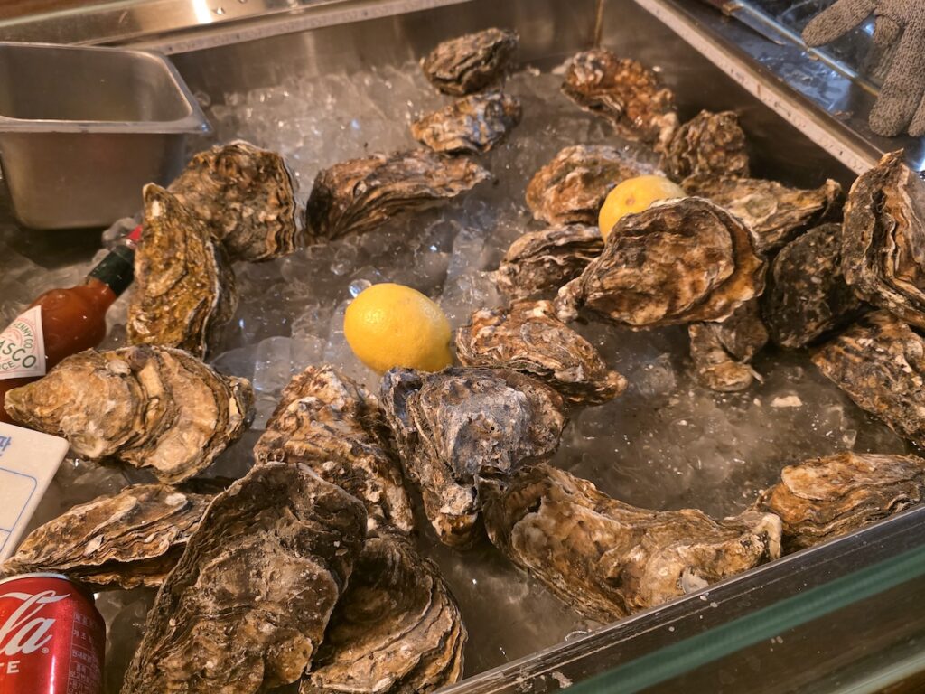 Korean oysters displayed on ice showing freshness at a seafood bar