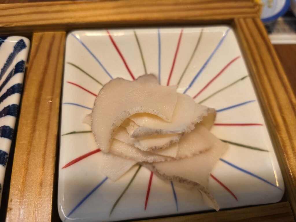 A close-up of a bowl of steamed white clams (shellfish) served as a low-calorie, high-protein side dish in a Korean seafood restaurant for weight-loss.