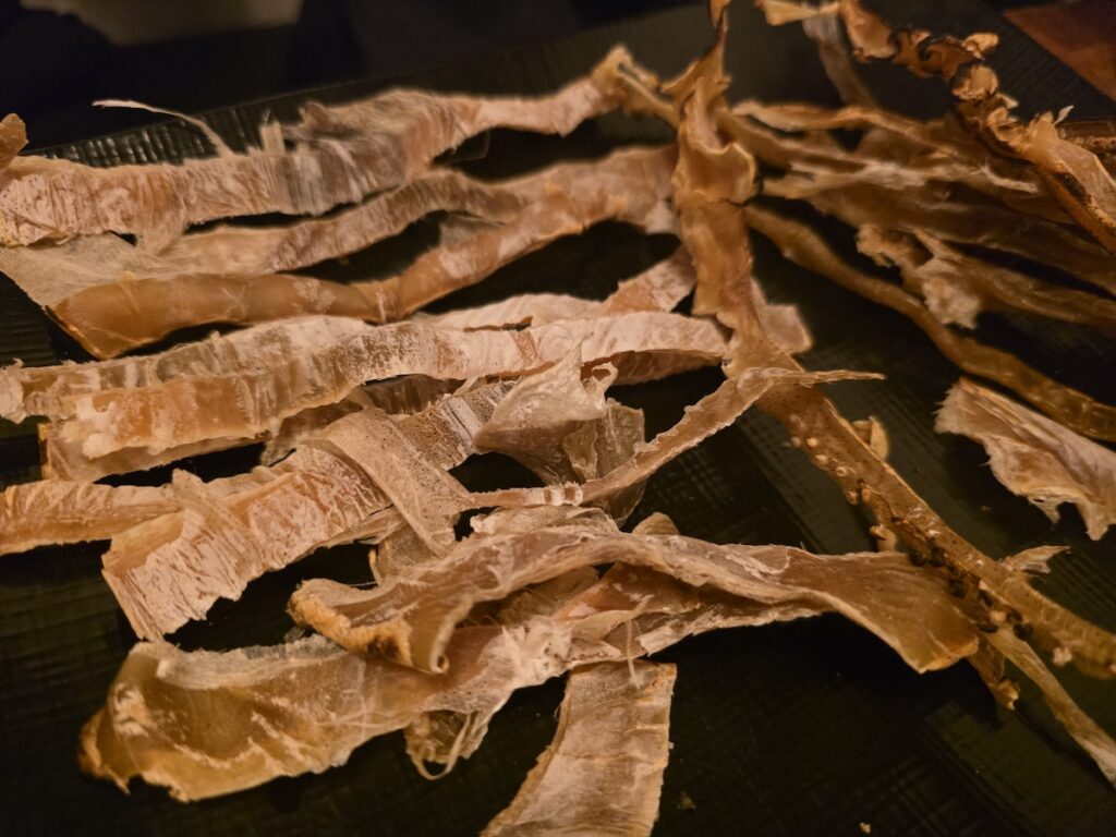 Grilling Korean dried squid over an open flame until it puffs
