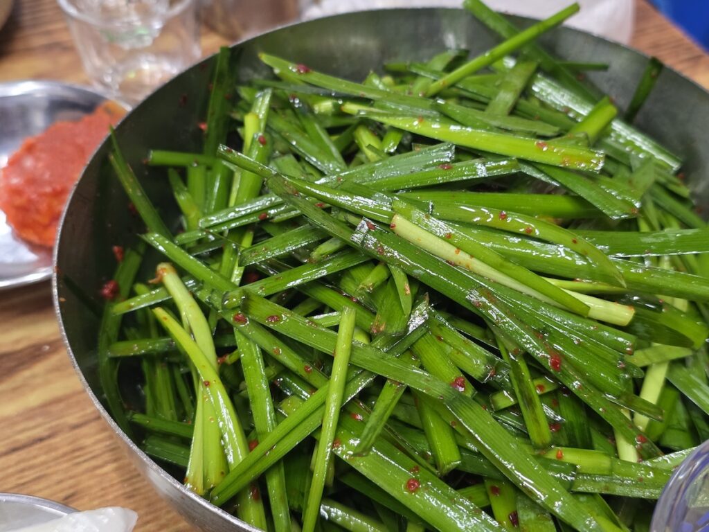 Bowl of Korean garlic chives (buchu) side dish served with beef intestines gopchang