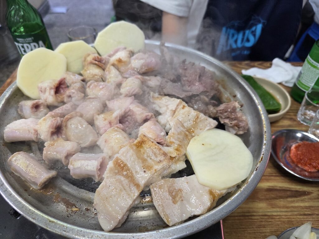 Korean beef intestines gopchang modeum platter cooking on a round pan with Terra beer and soju